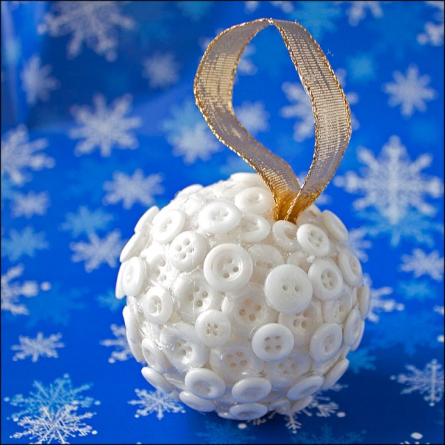 Styrofoam ball covered in small white buttons.