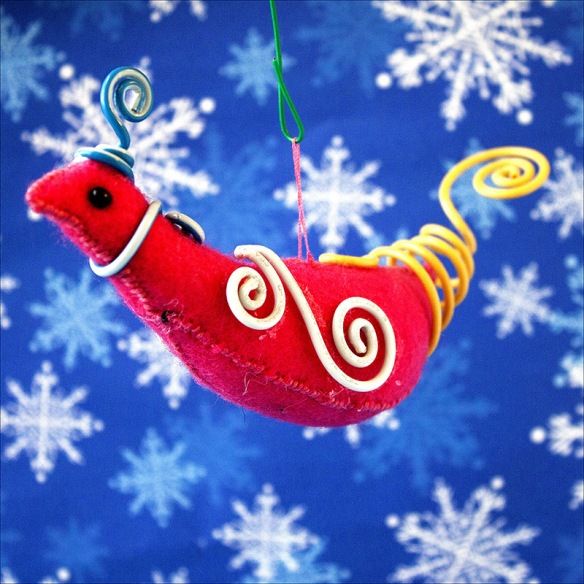 Felt bird with wire-wrapped crown, wings and tail in steam punk fashion.