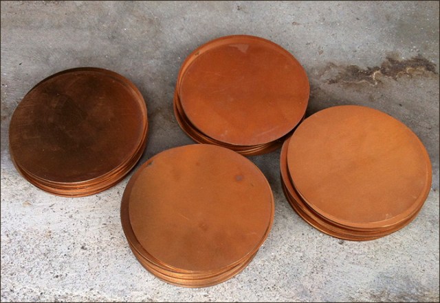 Photo of 4 stacks of copper discs.