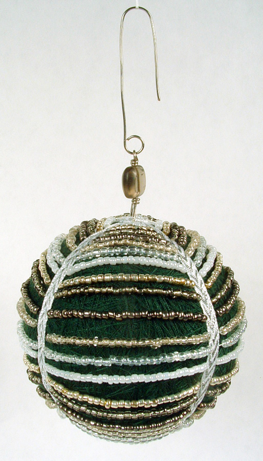 Green thread ball draped with stands of seed beads.