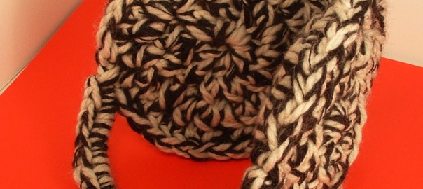 Crocheted earmuffs in cream and black wool yarn.