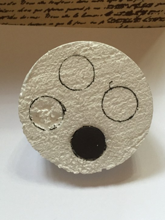 styrofoam ball cut in half, cutting holes to insert weights